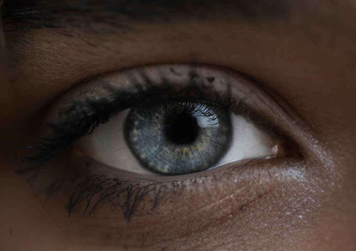 Extreme macro extreme close-up shot of a clear blue human eye showing cornea moisture and hydration